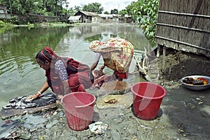 Bangladeshi women washing clothes in a lake