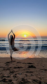 Bangli - Girl practising yoga on the beach during the sunset