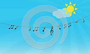 Musical notes and treble clef hanging on a rope against blue sky