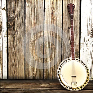 A Banjo leaning on a wooden fence.