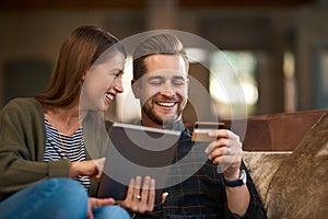 Bank, card and couple with tablet for credit score, loan or mortgage, payment and application on sofa at home. Ecommerce