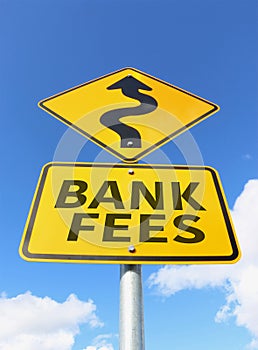 Bank fees increasing on a yellow and black road sign in a blue sky