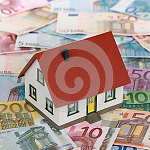 Bank financing a real estate with a house on banknotes