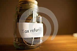 bank, jar of money with inscription tax refund and dollars