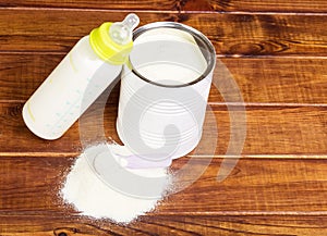 Bank milk powder, baby bottle with mixture in dark Dere.