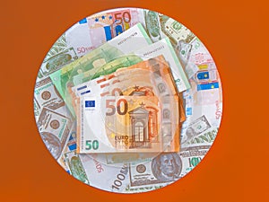 Bank notes on a plate on an orange background