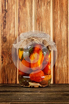 Bank of pickled tomatoes on wood