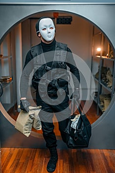 Bank robbery, robber in black uniform and mask