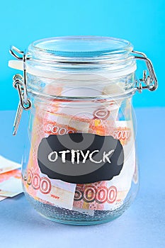 Bank with Russian money, 5000 rubles. Finance, moneybox, education. Text in Russian: vacation