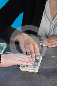 A bank teller accepts money from a client who transfers the cash to be paid into a bank account