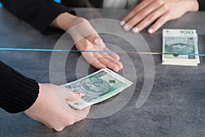 A bank teller accepts money from a client who transfers the cash to be paid into a bank account