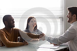 Bank worker congratulating couple taking loan signing family mortgage contract