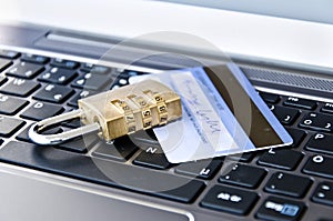 Banking card and padlock lying on keyboard