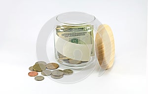 Banknote and coins in glass jar with copy space on the jar