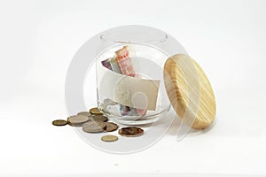 Banknote and coins in glass jar with copy space on the jar