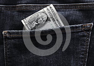 Banknote of north american one dollar bill in blue jeans pocket background. bill of 1 american bucks sticking out of the back