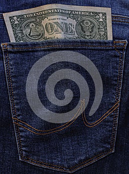 Banknote of north american one dollar bill in blue jeans pocket background. bill of 1 american bucks sticking out of back denim