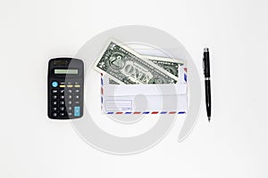 Banknotes in airmail envelope and black pen with calculator on white background.