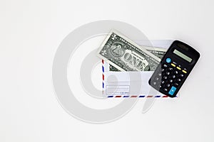 Banknotes in airmail envelope with calculator on white background.