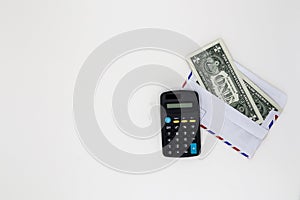 Banknotes in airmail envelope with calculator on white background