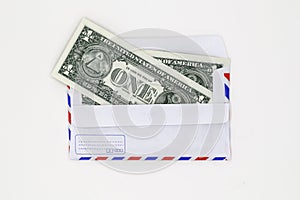 Banknotes in airmail envelope on white background.