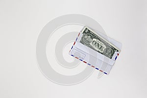 Banknotes in airmail envelope on white background.