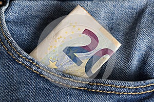 Banknotes bills of Euro currency sticking out of the blue jeans pocket.