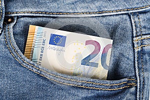 Banknotes bills of Euro currency sticking out of the blue jeans pocket.