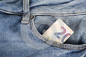 Banknotes bills of Euro currency sticking out of the blue jeans pocket.