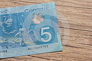 Banknotes of Canadian currency: Dollar. Bils on wood rustic table.