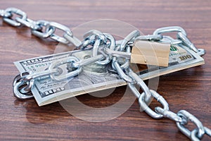 Banknotes With Chain And Padlock On Table