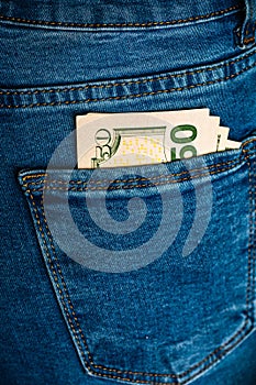 Banknotes close up, money in a jeans pocket. Dollars stick out of the jeans pocket, finance and currency concept. Concept of
