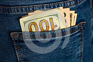 Banknotes close up, money in a jeans pocket. Dollars stick out of the jeans pocket, finance and currency concept. Concept of