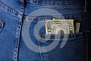 Banknotes close up, money in a jeans pocket. Dollars stick out of the jeans pocket, finance and currency concept. Concept of