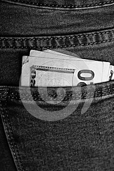Banknotes close up, money in a jeans pocket. Dollars stick out of the jeans pocket, finance and currency concept. Concept of