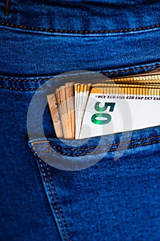 Banknotes close up, money in a jeans pocket. EURO stick out of the jeans pocket, finance and currency concept. Concept of saving