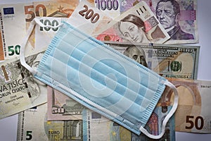 Banknotes of different countries background, top view and medical face mask