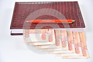 Banknotes five thousand rubles are used as bookmarks in the business diary