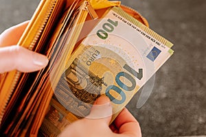 Banknotes in hand.The hand takes out one hundred euro bill from the wallet.