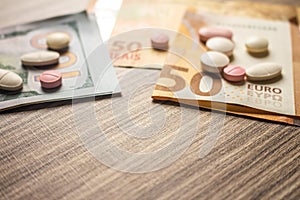 Banknotes and medicines on a desk. Health cost concept. Money and drugs for legal use