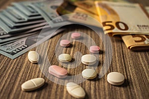 Banknotes and medicines on a desk. Health cost concept. Money and drugs for legal use