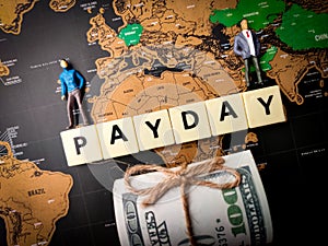 Banknotes,miniature people and toys word with text PAYDAY
