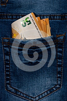 Banknotes, money in a jeans pocket, close up. Money stick out of the jeans pocket, finance and currency concept. Concept of rich