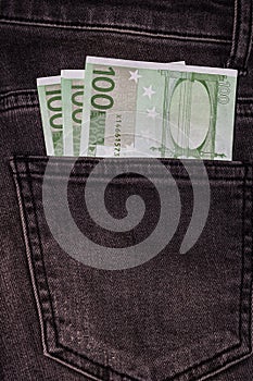 Banknotes, money in a jeans pocket, close up. Money stick out of the jeans pocket, finance and currency concept. Concept of rich