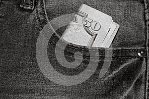 Banknotes, money in a jeans pocket, close up. Money stick out of the jeans pocket, finance and currency concept. Concept of rich