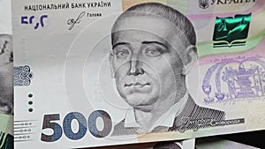 Banknotes in nominal value of 500 hryvnias fall on a black table and slowly rotate. Ukrainian national currency. Revolving cash pa