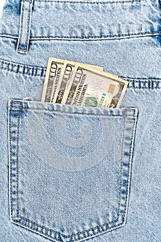 banknotes in the pocket of blue jeans. ten dollars bills.