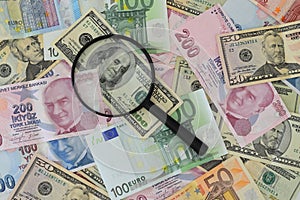 Banknotes spread out on a table with a calculator and a magnifying glass.