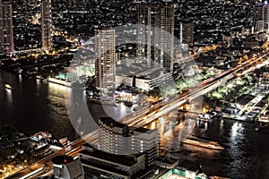 Bankok skyline by night highway and river traffic