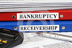 Bankruptcy and receivership files stacked on a desk in close-up photo